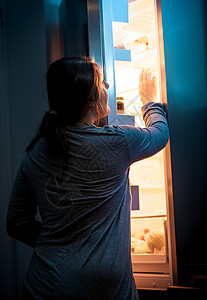 夜间开放昙花年轻妇女夜间打开冰箱的肖像背景