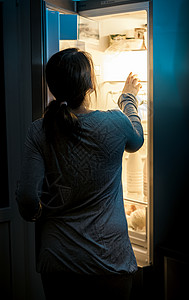 半夜在冰箱里看饥饿女人的肖像图片