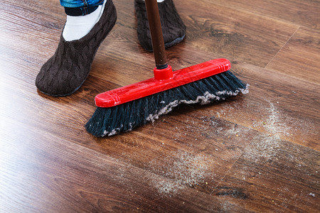 清洁家务概念关闭扫帚和女脚清洁工扫木地板高清图片