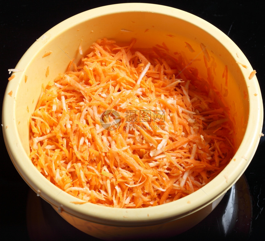 碗蔬菜沙拉黑背景的胡萝卜图片