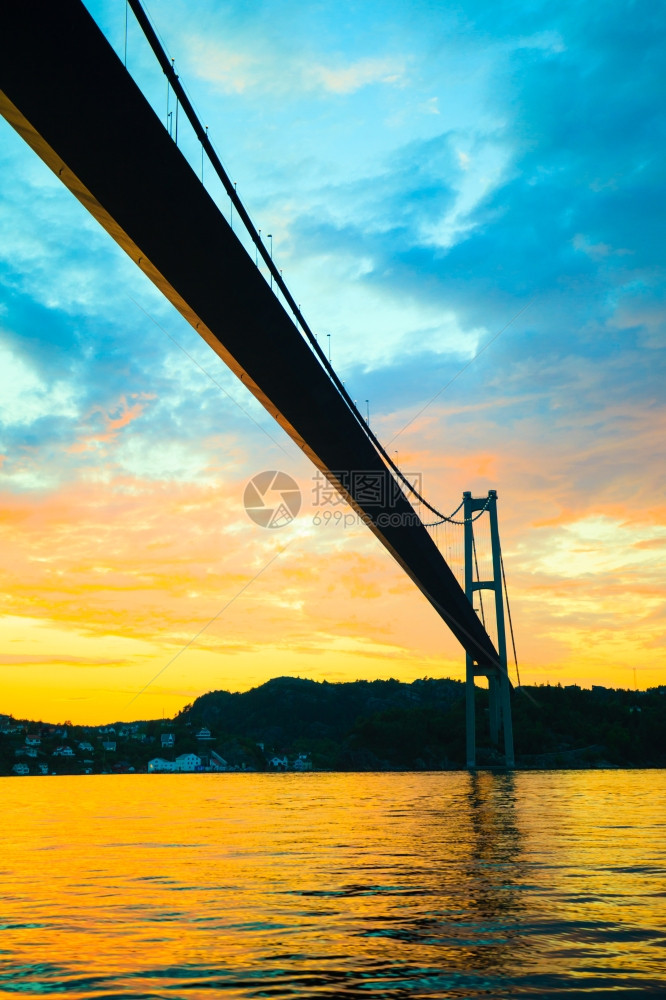在挪威卑尔根的海面和长悬浮桥上有戏剧日落云层图片