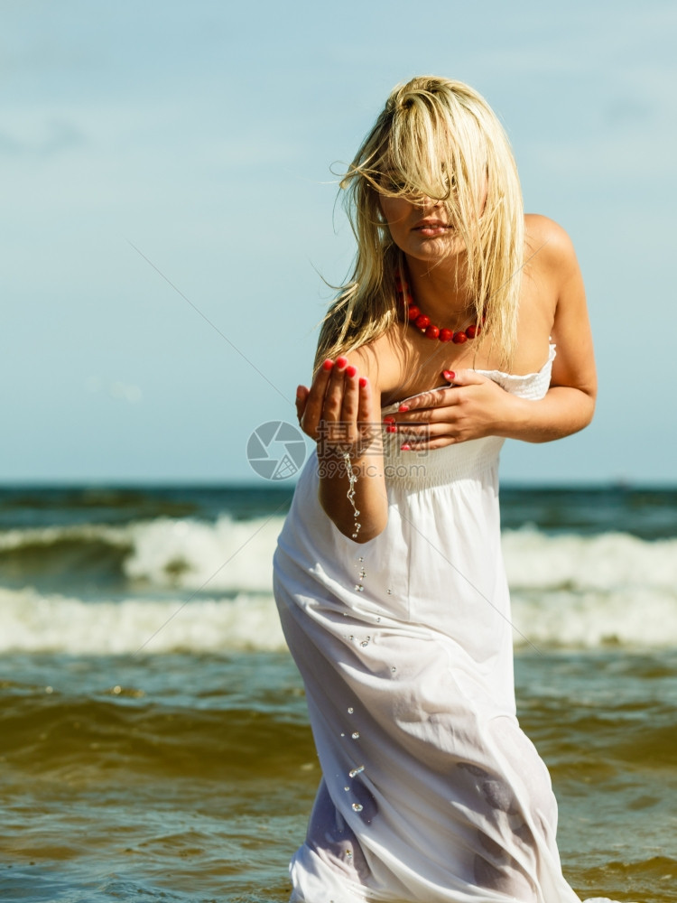 度假旅行和自由概念穿着白衣在海滩上泼水的漂亮女孩年轻人在海边放松愉快图片