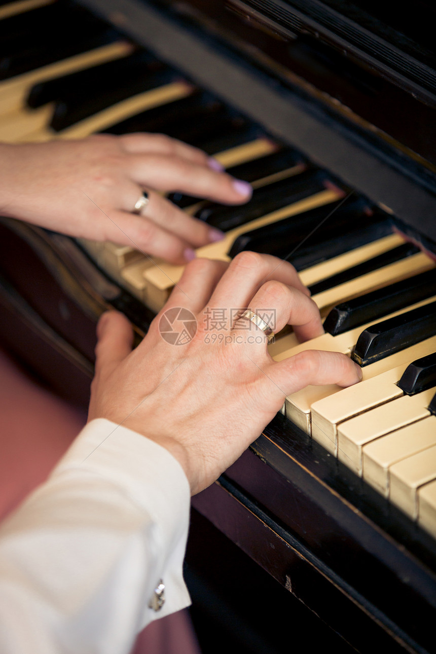 新婚夫妇弹钢琴的近照片图片