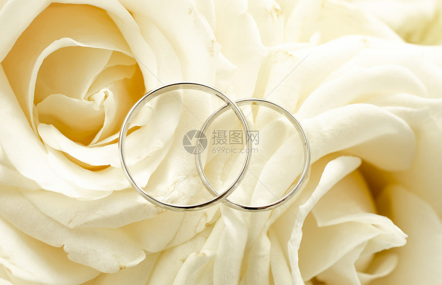 两枚结婚戒指的宏观镜头躺在新娘花束上图片