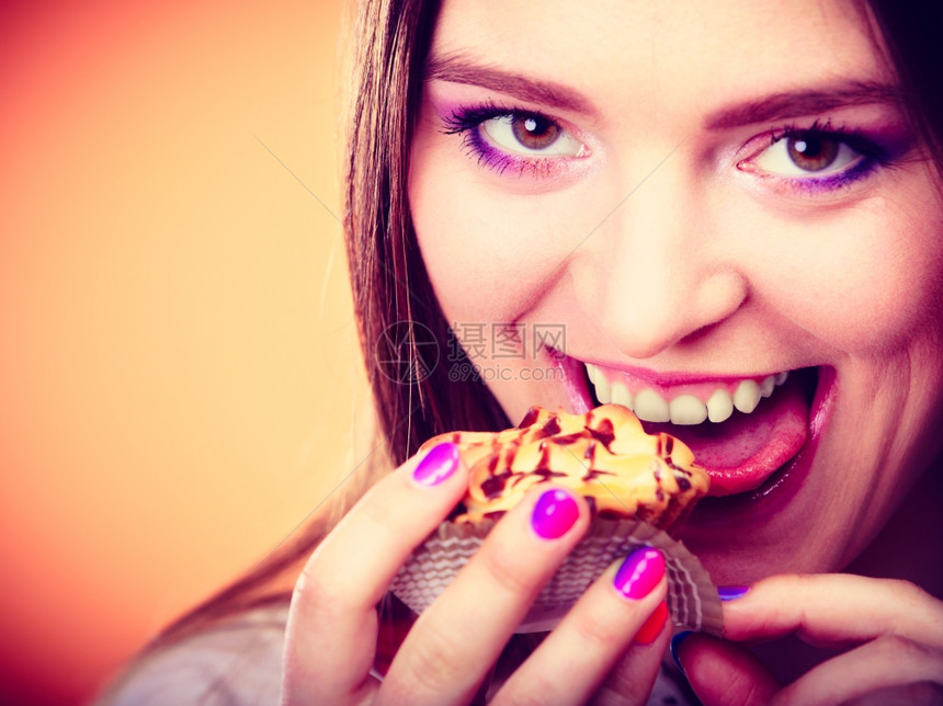 微笑的女人手持蛋糕橙色背景图片