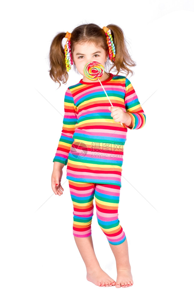 身穿亮条纹裙子的女孩拿着糖果贴在脸上图片