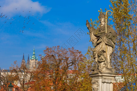 圣奥古斯丁雕刻的圣奥古斯丁雕刻着燃烧的心脏手在捷克布拉格CharlesBridge上践踏异教书籍背景图片
