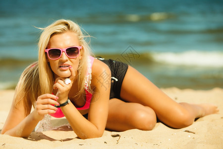 度假旅行和自由概念美丽的金发女在海滩上晒黑的感女孩穿着粉色太阳眼镜的年轻女人在海边放松背景图片