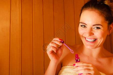 Spa美容治疗和放松概念妇女在木制桑拿室休息享受发泡肥皂的乐趣图片