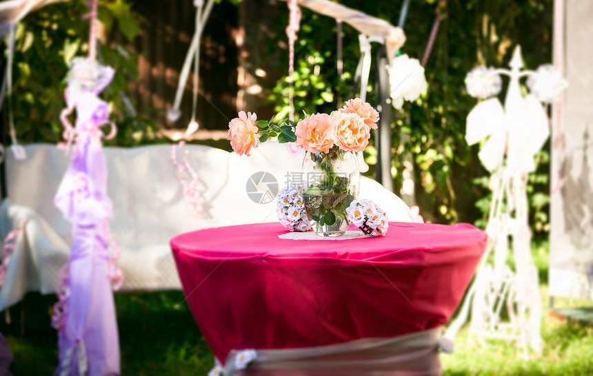 粉红玫瑰的近镜头站在院子里装饰的桌上图片