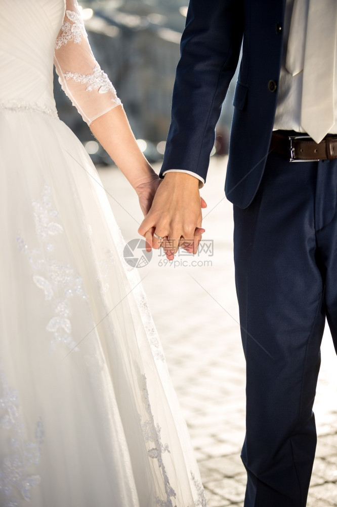 新娘和郎在户外握手的近照图片