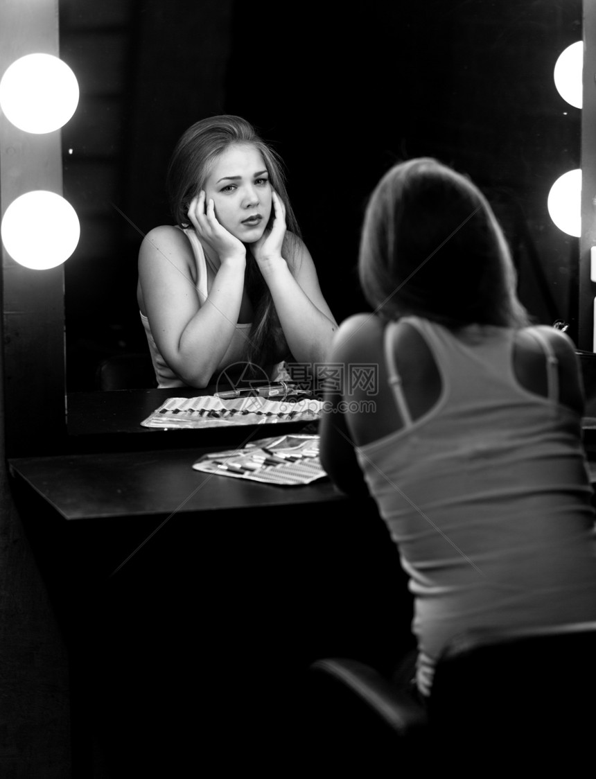 黑色和白的悲哀妇女肖像用灯泡照镜子图片