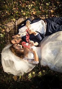 新娘和郎的肖像躺在草地上握着爱标志图片