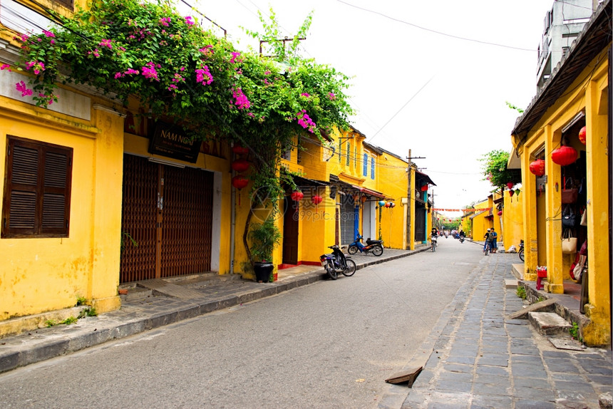 越南广Hoi古城配有肩杆和牙帽的街摊商图片