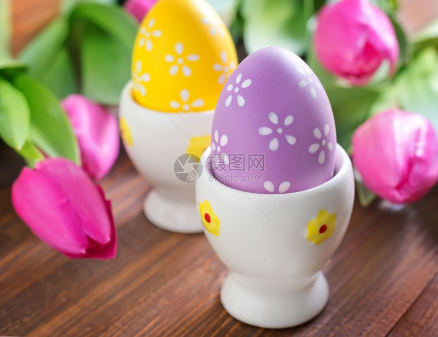 粉红色郁金香和杯子里的彩色鸡蛋图片