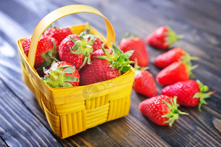 装着草莓篮子装在黄色篮子里的草莓背景