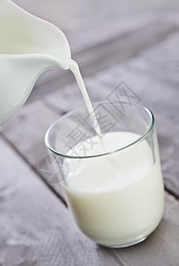 纯牛奶倒入透明玻璃杯图片