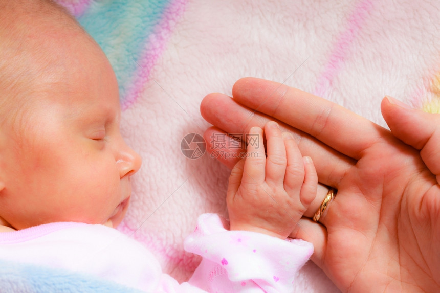 闭上小手母亲掌中睡着的女婴图片