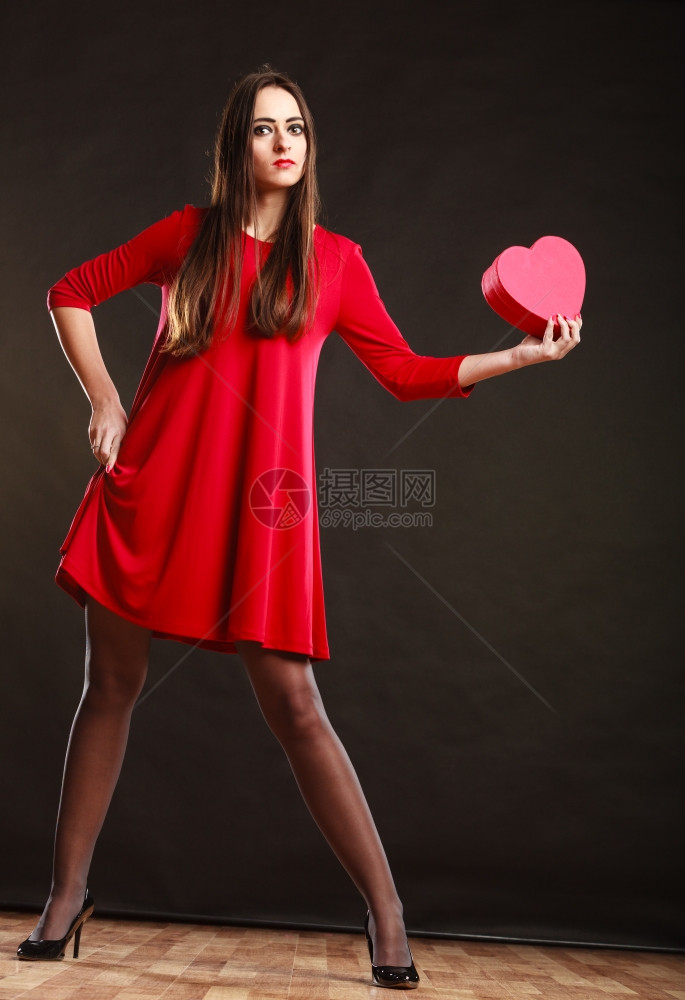 情人节快乐和关系概念穿红裙子的长发女郎带着心爱的象征穿着深灰色背景的舞姿图片