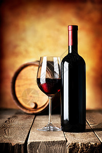 瓶装红酒和木制桌上的桶装红酒图片