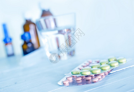 桌上的玻璃水和药片背景图片