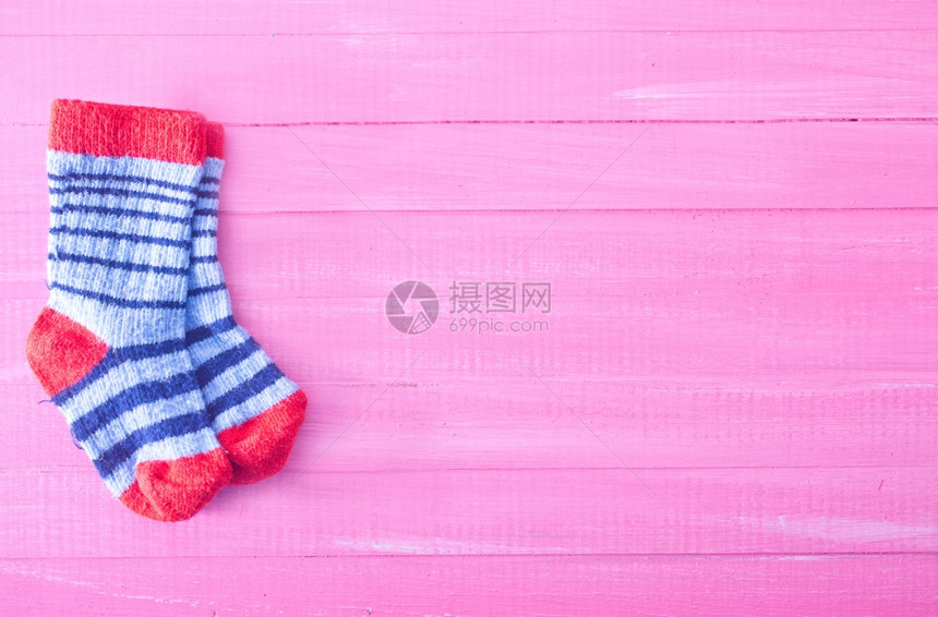 粉红色木制桌上的婴儿袜子图片