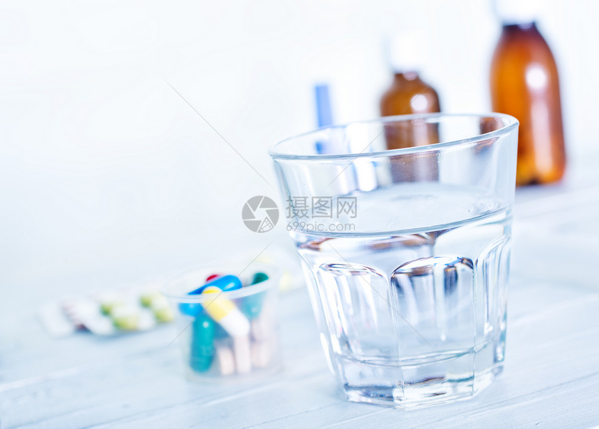 医疗药丸和桌上的水图片