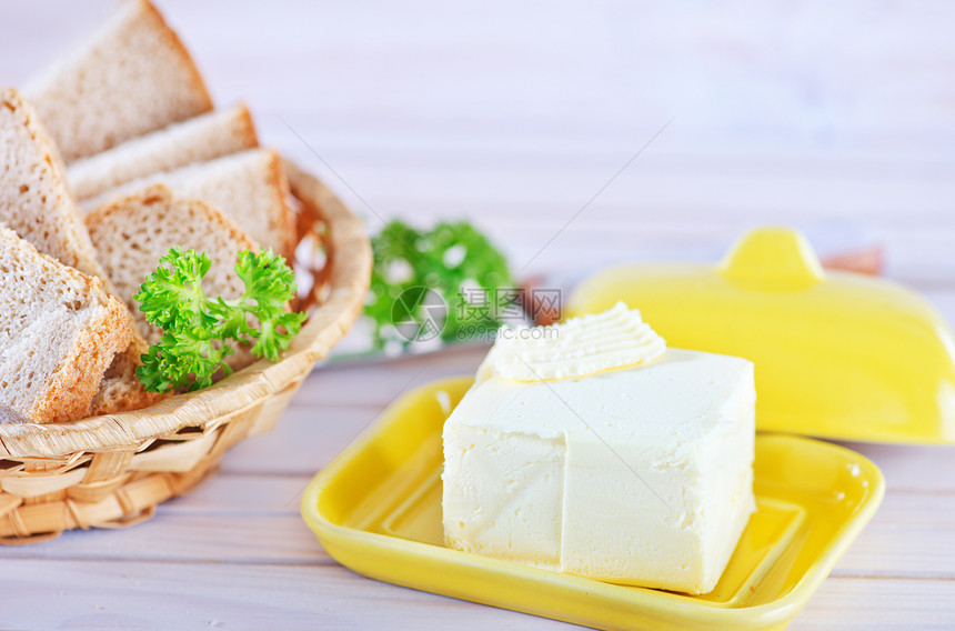 木桌上的黄油和面包图片