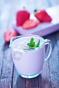 草莓酸奶在玻璃壶和桌上图片