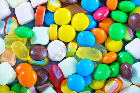 甜口香糖盘中和桌上的糖果彩色背景