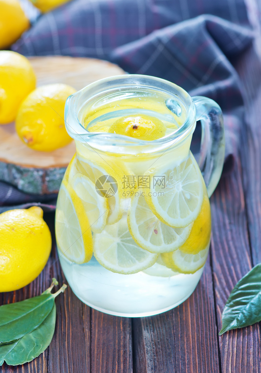罐中和桌上的新鲜柠檬汁图片