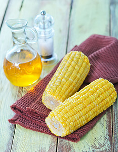 在餐巾纸和桌子上煮熟的玉米图片