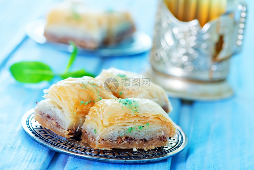 Baklava土耳其在金属板和桌子上的甜点图片