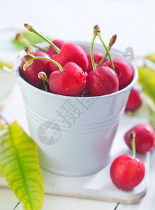 白桶和桌上的樱桃水果图片