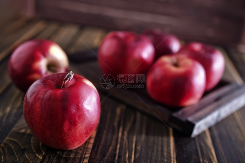 木制桌上的新红苹果图片