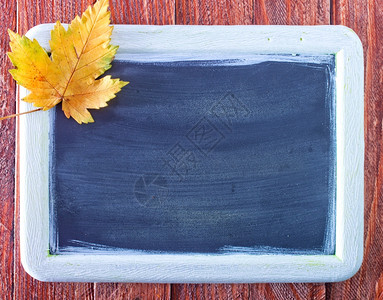 秋背景彩叶和黑板在表格上图片