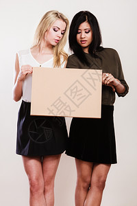 广告概念两名女艺人和非洲空板横旗纸演播室拍到背景图片
