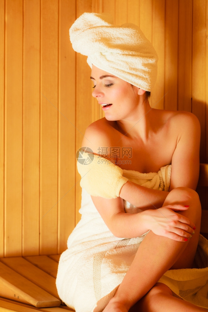 女白毛巾在木制桑拿室休息用脱花手套按摩图片