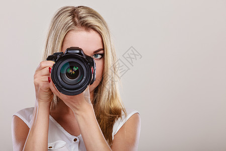 摄影师女孩拍图像迷人的金发美女拿着相机拍照背景图片