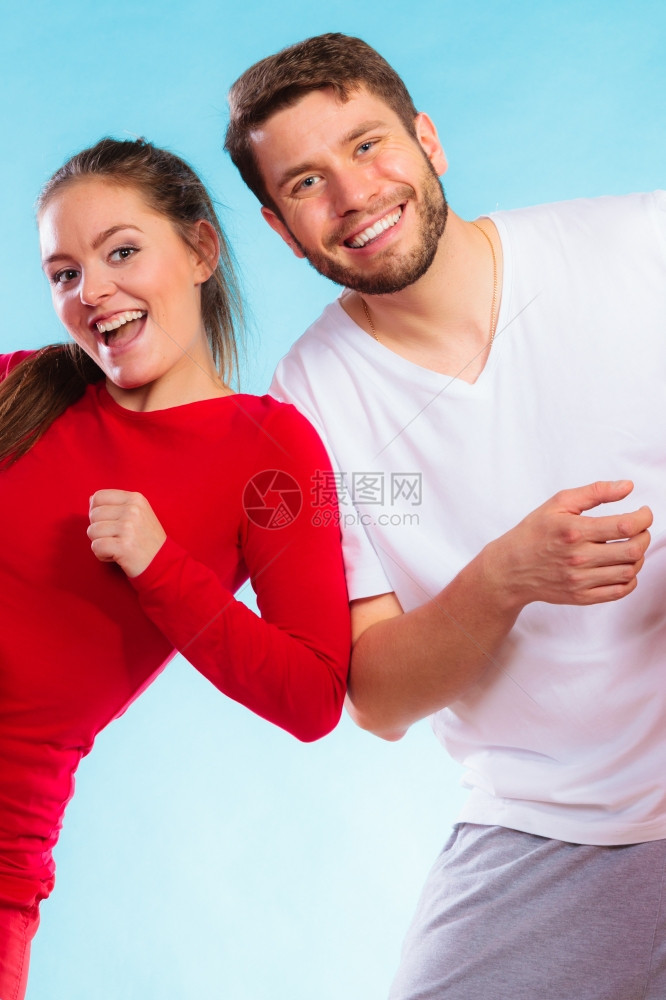 运动概念的年轻快乐情侣男女在蓝背景上玩得开心的肖像图片