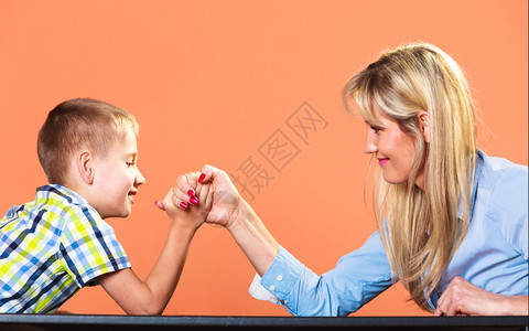 中年母亲女人和小男孩的手臂摔跤玩得开心图片
