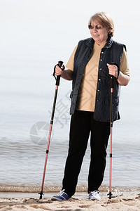 活跃的成熟生方式老年卫士在沙滩海岸上行走图片