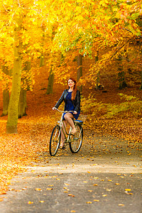 时尚女郎在公园骑着自行车背景图片