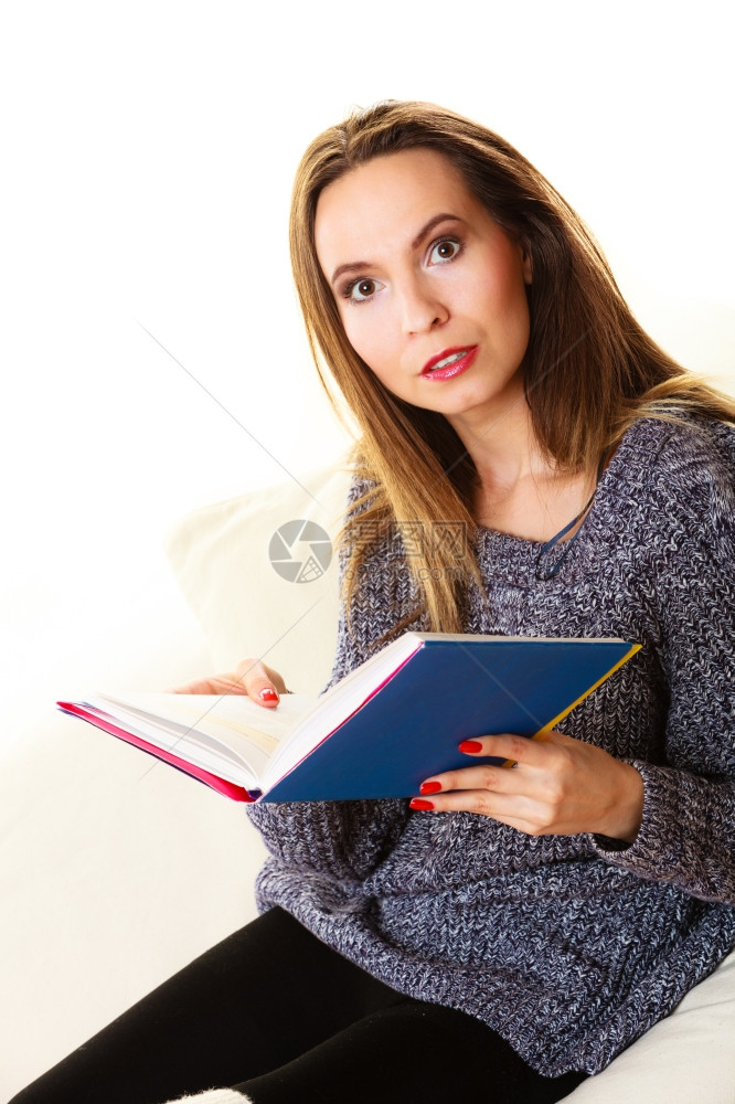 休闲教育文学和家庭概念坐在沙发上家里看书的妇女图片