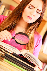 探索教育概念图书馆里有超近智能趣的学生女孩人拿着放大镜图片