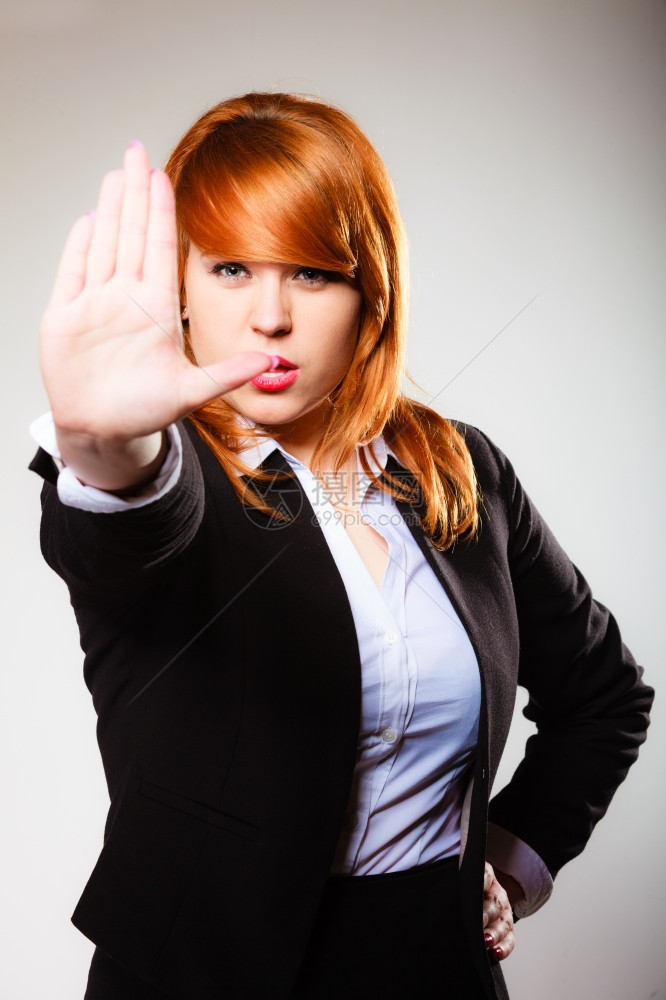 红头发女商人手牌势在灰色上停止商业概念工作室拍摄图片