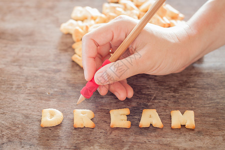 饼干写字框木制桌上的梦想字母饼干股票照片背景