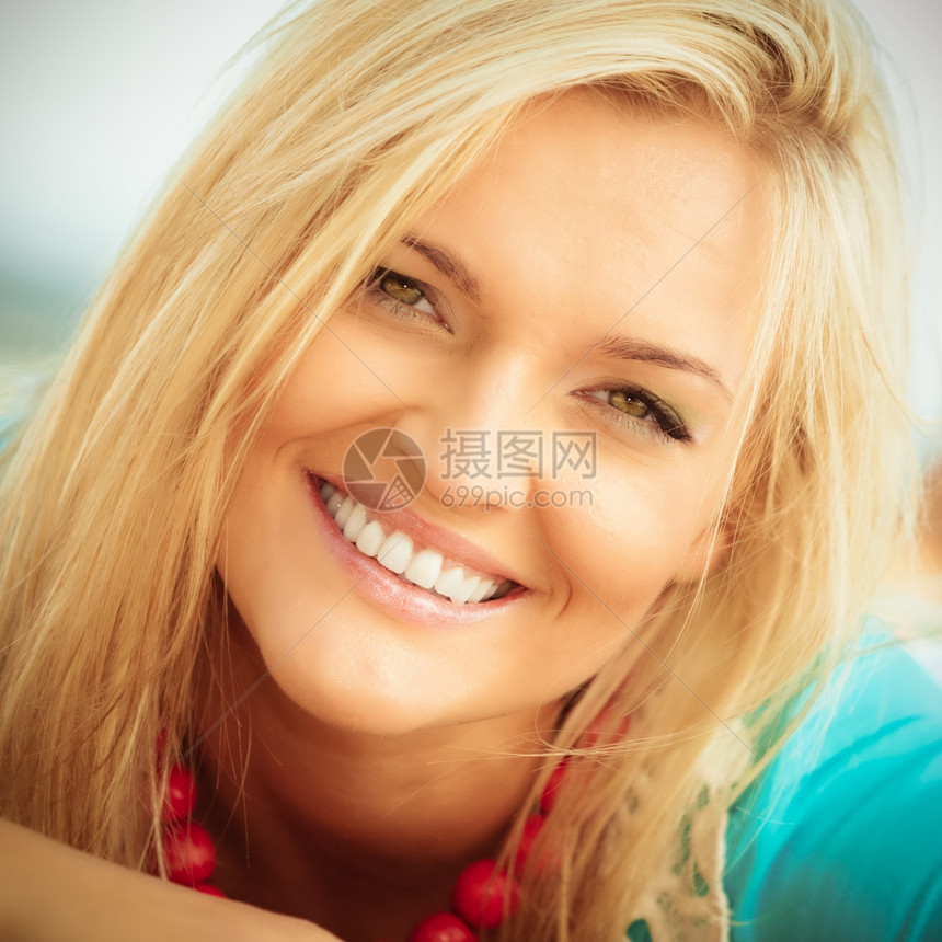 度假旅行和自由概念关闭有吸引力的金发女孩在沙滩上放松肖像图片