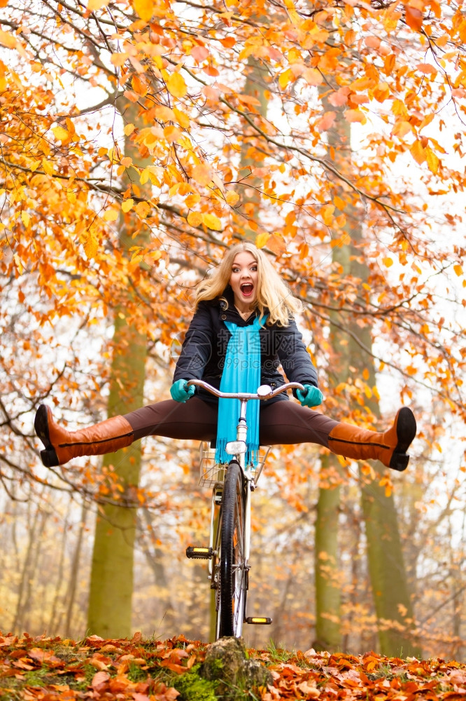 时尚女郎在公园骑着自行车玩特技图片