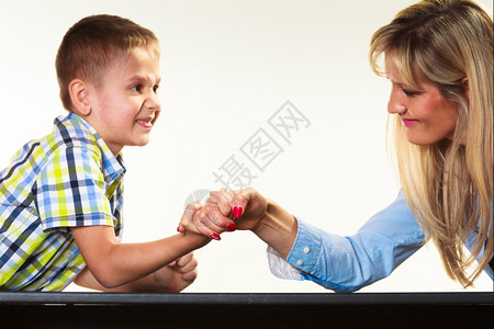 母亲和小男孩的手臂摔跤玩得开心图片